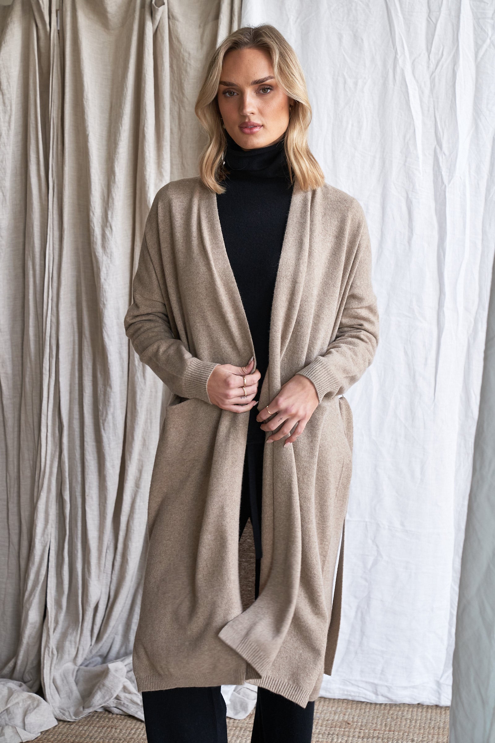 Long Mushroom Cashmere Cardigan with Belt & Pockets – Women’s Coatigan | 100% Pure Cashmere

Wrap yourself in luxury with our long cashmere cardigan in mushroom, designed with a soft belted waist and practical front pockets. Made from 100% pure, ethically sourced cashmere, this elegant coatigan-style knit offers a relaxed, robe-like silhouette perfect for layering during cooler months.

The neutral taupe-grey tone makes it endlessly versatile, while the detachable belt allows for multiple styling options. W