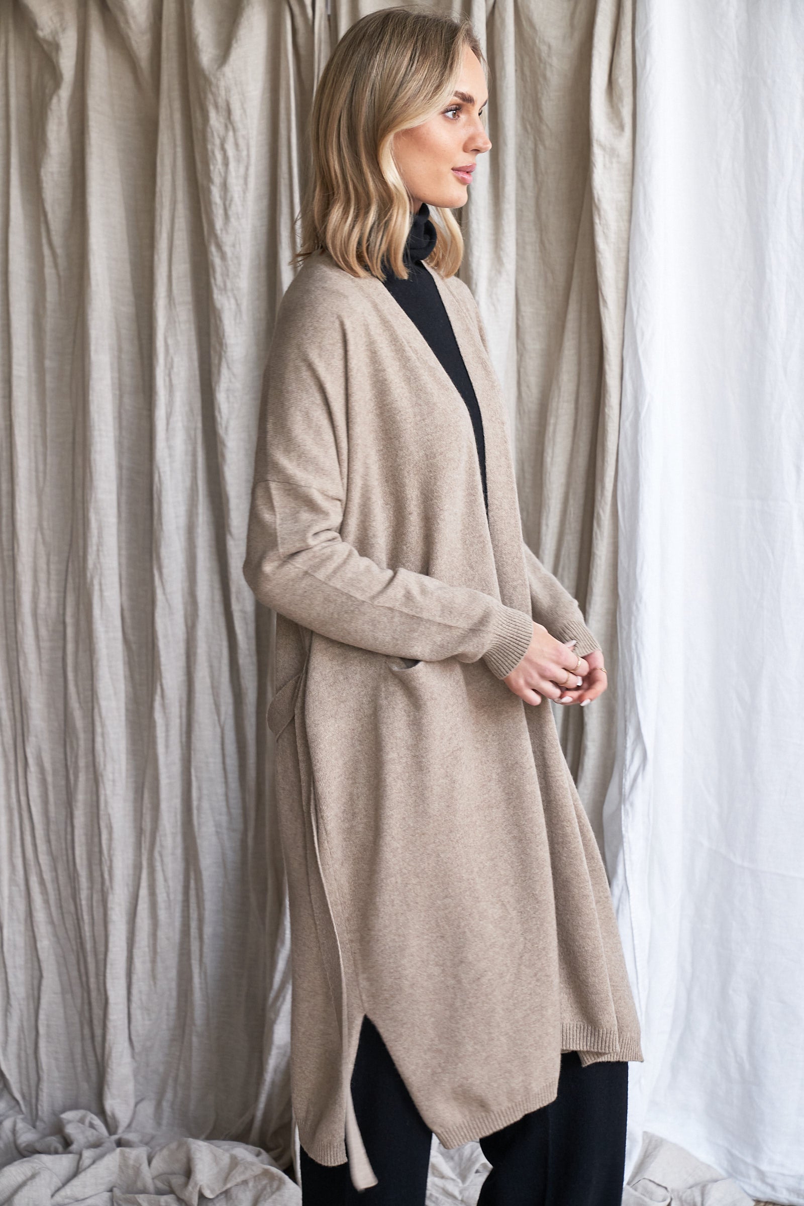Long Mushroom Cashmere Cardigan with Belt & Pockets – Women’s Coatigan | 100% Pure Cashmere

Wrap yourself in luxury with our long cashmere cardigan in mushroom, designed with a soft belted waist and practical front pockets. Made from 100% pure, ethically sourced cashmere, this elegant coatigan-style knit offers a relaxed, robe-like silhouette perfect for layering during cooler months.

The neutral taupe-grey tone makes it endlessly versatile, while the detachable belt allows for multiple styling options. W